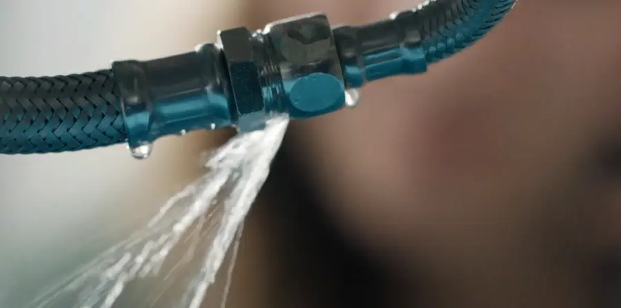 Braided appliance supply hose spraying water from a failed fitting